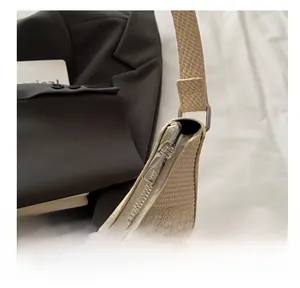 Close-up of smooth silver zipper closure on beige woven textured shoulder bag