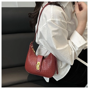 Close-up of red crescent bag featuring crocodile pattern leather and golden metal ring