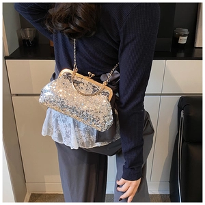 Detailed view of shimmering silver sequin shell bag with a gold metal chain strap