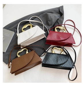 Détail de sacs à main tressés en quatre couleurs avec poignées métalliques dorées