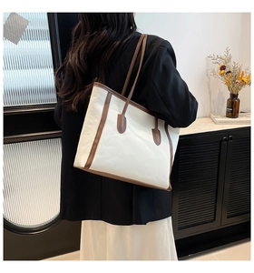 Side view of a large cream and brown tote bag worn on shoulder for commuting