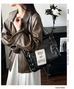 Detail of black transparent PVC tote bag with cross-lace side design and slogan card