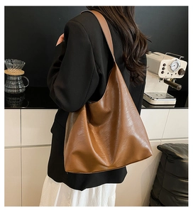 Detail view of the brown leather texture and spacious interior of the large tote bag
