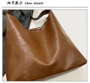 Close-up of caramel brown tote bag showing textured soft leather and wide strap detail