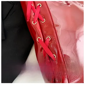 Macro detail of red patent leather with elegant ribbon lacing and gold metal eyelets