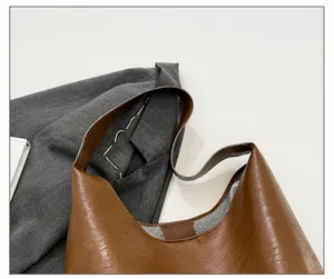 Detail shot of the wide comfortable shoulder strap on a brown pebbled leather tote bag