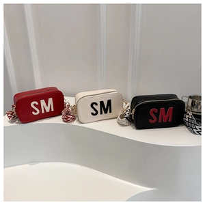 Drei eckige Umhängetaschen in Rot, Beige und Schwarz mit SM-Logo und Ethno-Gurt