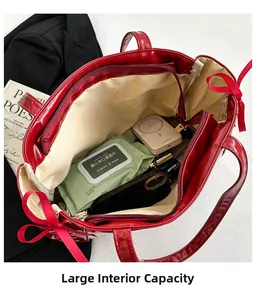 Top view of large capacity red patent leather tote bag with ribbon bow and interior storage