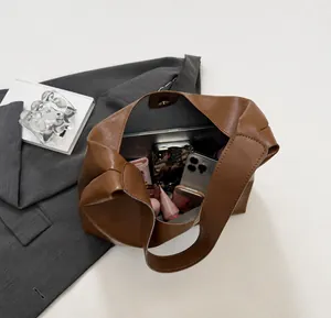 Spacious interior of a brown leather tote showing storage for tablets and phones