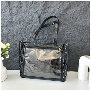 Detail of black ita bag with clear PVC window and side ribbon lace-up decoration