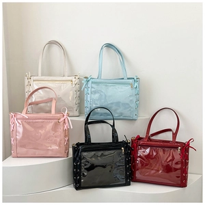 Detail of five colorful ita bags featuring transparent PVC windows and side ribbon bows