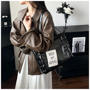 Detail of trendy ribbon tote bag with side lacing and metallic eyelets on clear PVC