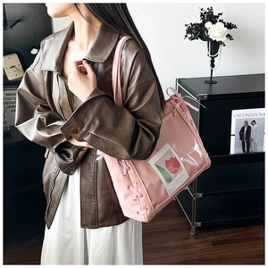 Detail view of pink ribbon lacing and transparent pocket on fashion tote bag