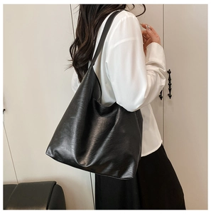 Detailed view of large black tote bag with textured soft leather and shoulder strap