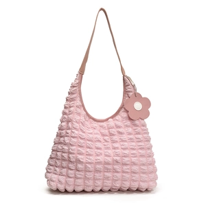 Pink bubble texture tote bag with pleated fabric and a floral charm on white background