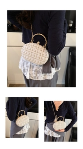 Detail of tweed shell evening bag with pearl handle and golden chain strap
