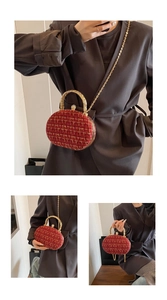 Detail of red tweed circular evening bag with crystal buckle and gold chain strap