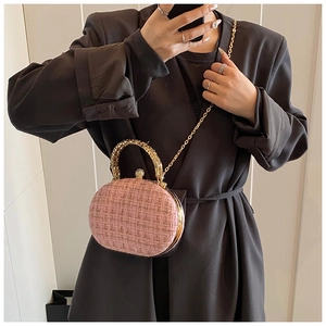 Dettaglio borsa da sera in tweed rosa con manico ad anello dorato e chiusura a diamante