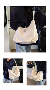 Detail view of large white canvas crescent bag with fashion label and shoulder strap