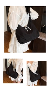Detail of black nylon tote featuring a distinctive black and white woven drawstring closure