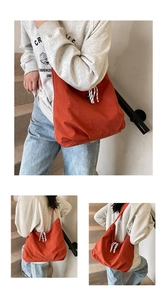 Detail of orange nylon tote bag showing drawstring closure and relaxed textured fabric