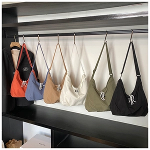 Six colors of large-capacity canvas hobo bags with adjustable straps on a display rack