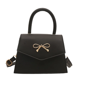 Chic black handbag with gold bow buckle and adjustable strap for spring 2025 fashion