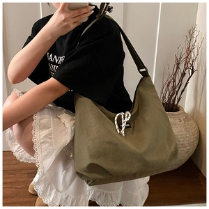 Detail of army green large canvas crossbody bag with white knot and fashion label