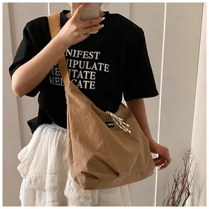Close-up of khaki canvas tote bag with adjustable wide strap and fashion label detail