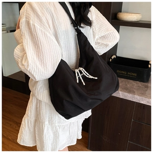 Detail of black large-capacity canvas crossbody bag with fashion striped rope accent
