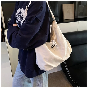 Detail of the white large-capacity tote bag with fashion label and zipper closure