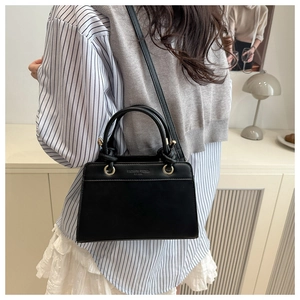 Detail of black stylish tote bag with golden ring buckle and fashion trend typography