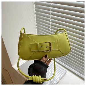 Close-up of vibrant lime green PU leather shoulder bag featuring a large metal buckle