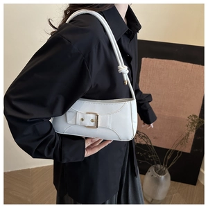 Detailansicht einer weißen Baguette-Schultertasche mit goldener Metallschließe