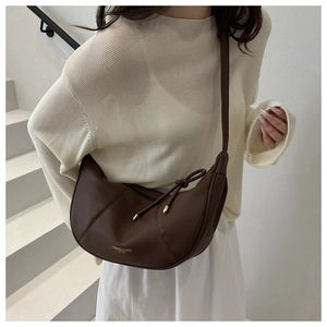 Detailed texture of dark brown lychee pattern leather dumpling bag with gold text