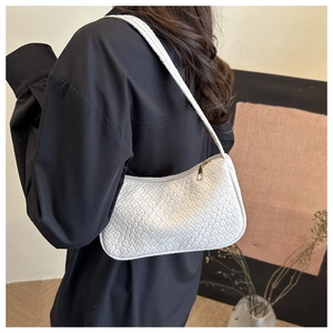 Detail of white woven crossbody bag showing luxury Intrecciato texture and gold zipper