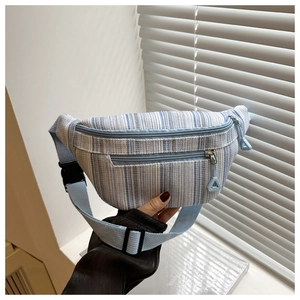 Detail of adjustable blue strap and striped woven fabric on large casual crossbody bag