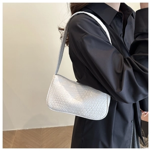 Close-up of white woven leather texture on a stylish rectangular baguette bag