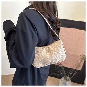 Detail of beige woven texture and slim shoulder strap on a stylish faux leather hobo bag