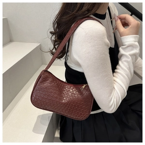 Detail view of burgundy faux leather underarm bag with retro woven crocodile pattern