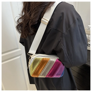 Detail of colorful metallic crossbody bag with rainbow stripes and gold hardware