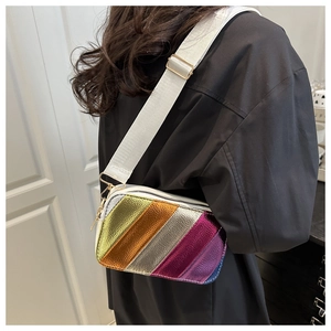 Detail view of colorful metallic striped crossbody bag with wide white fabric shoulder strap