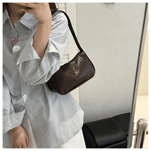 Gros plan détaillé du sac à bandoulière tressé marron foncé avec texture cuir