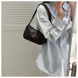 Détail du sac sous le bras tressé marron foncé montrant le motif de tissage