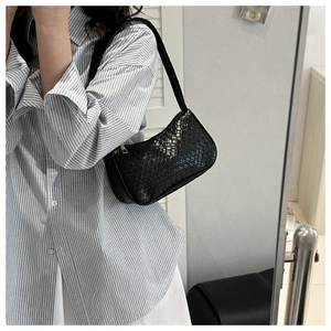 Détail du sac hobo tissé noir montrant la texture du cuir et le porté par le mannequin