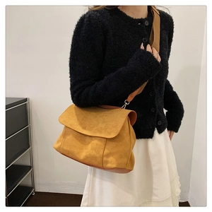Detail of ginger yellow suede crossbody bag with premium matte texture and leather strap