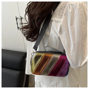 Detailed view of a metallic rainbow striped crossbody bag shown on a female model