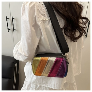 Detailed view of rainbow metallic crossbody bag with textured stripes and wide black strap