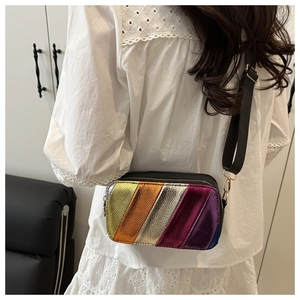 Detail view of rainbow striped crossbody bag with wide shoulder strap and gold hardware