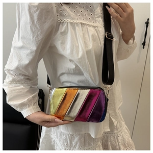 Rainbow striped crossbody bag with metallic finish and wide black strap on model